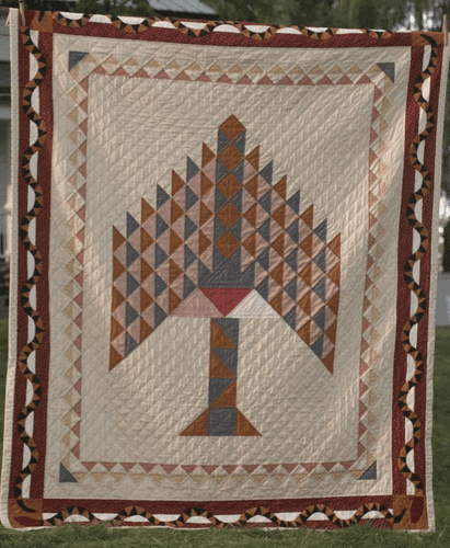 A tree of paradise quilt with a border of snakes and the three triangles of fabric from the three main women in the story.